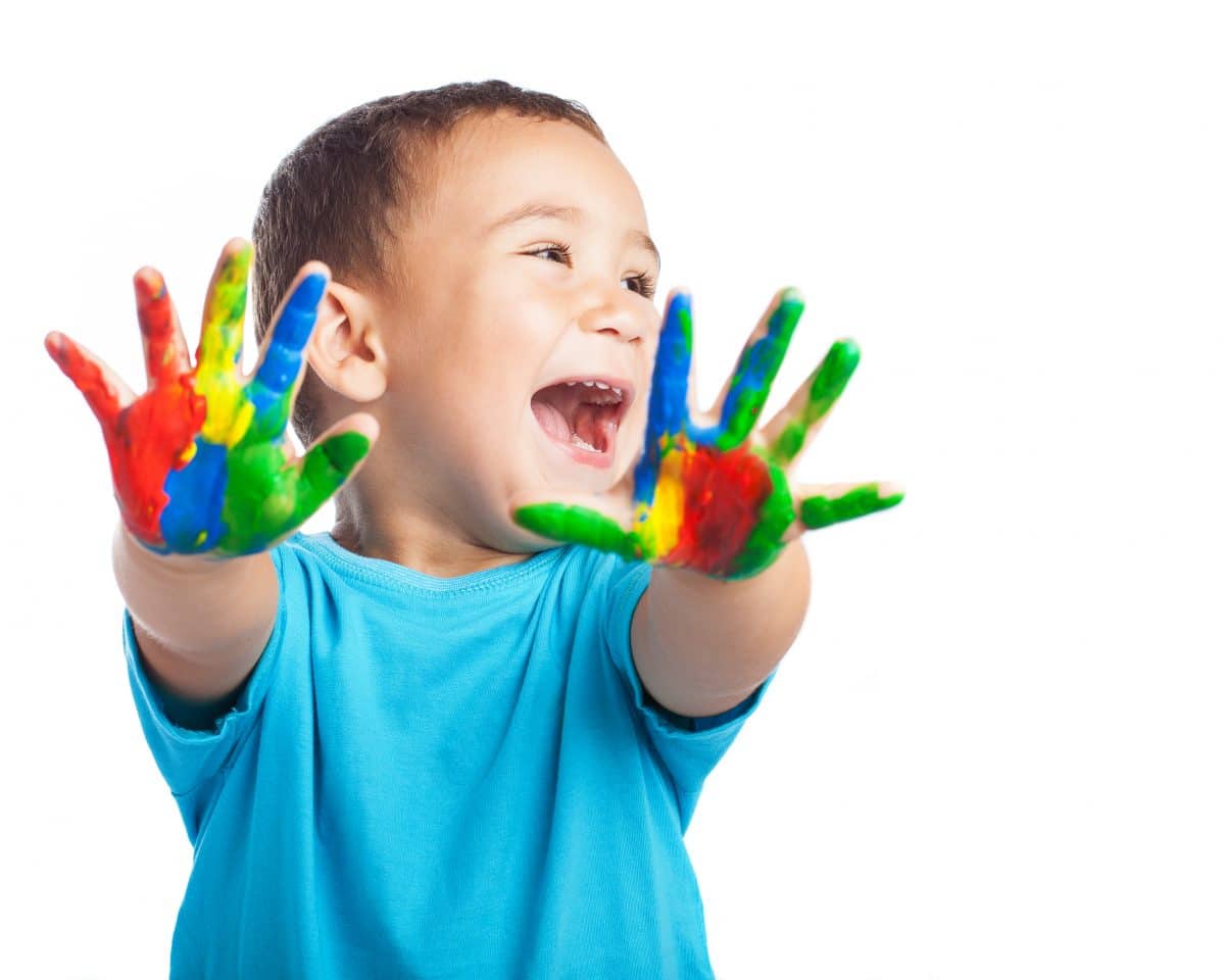 cheerful child with painted hands on white background